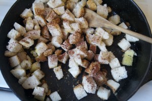 Add spices to bread cubes--feel free to adjust seasoning to taste—and stir to keep bread cubes from burning.