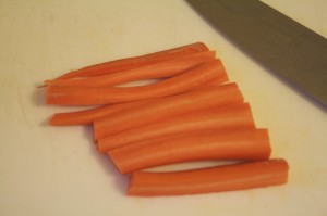 Slice carrots in half lengthwise, then in half again lengthwise. Now cut the quartered carrot in half and...