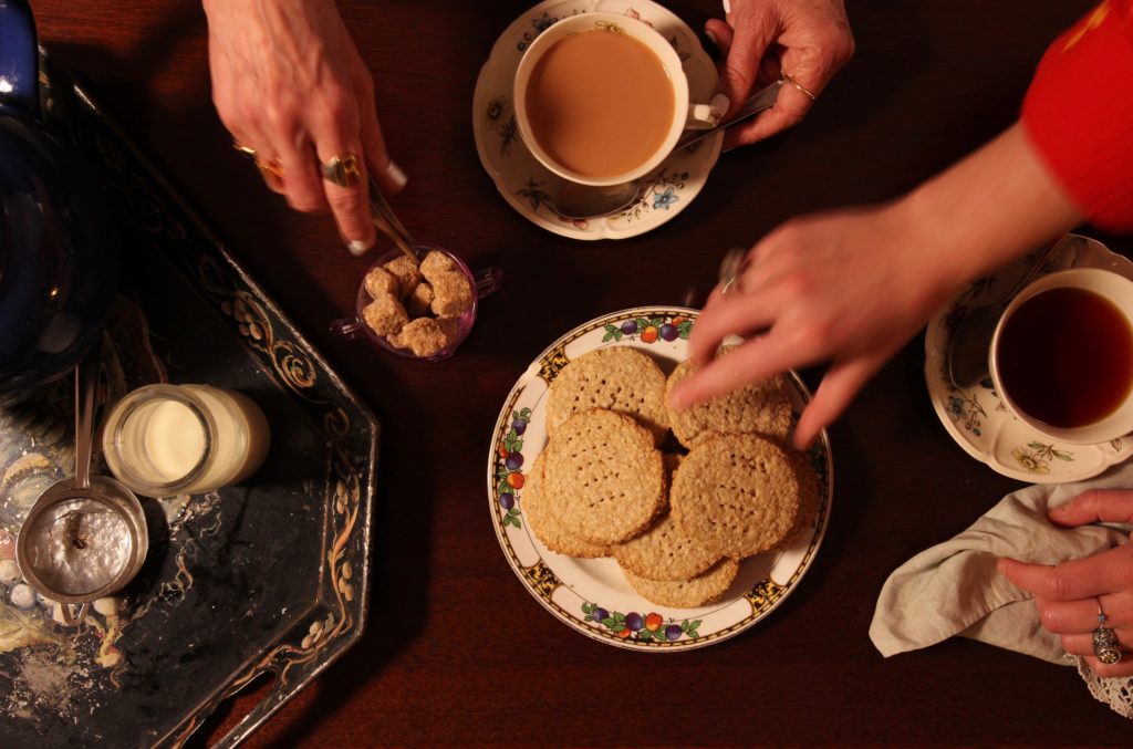 Busy hands, tea, digestive biscuite